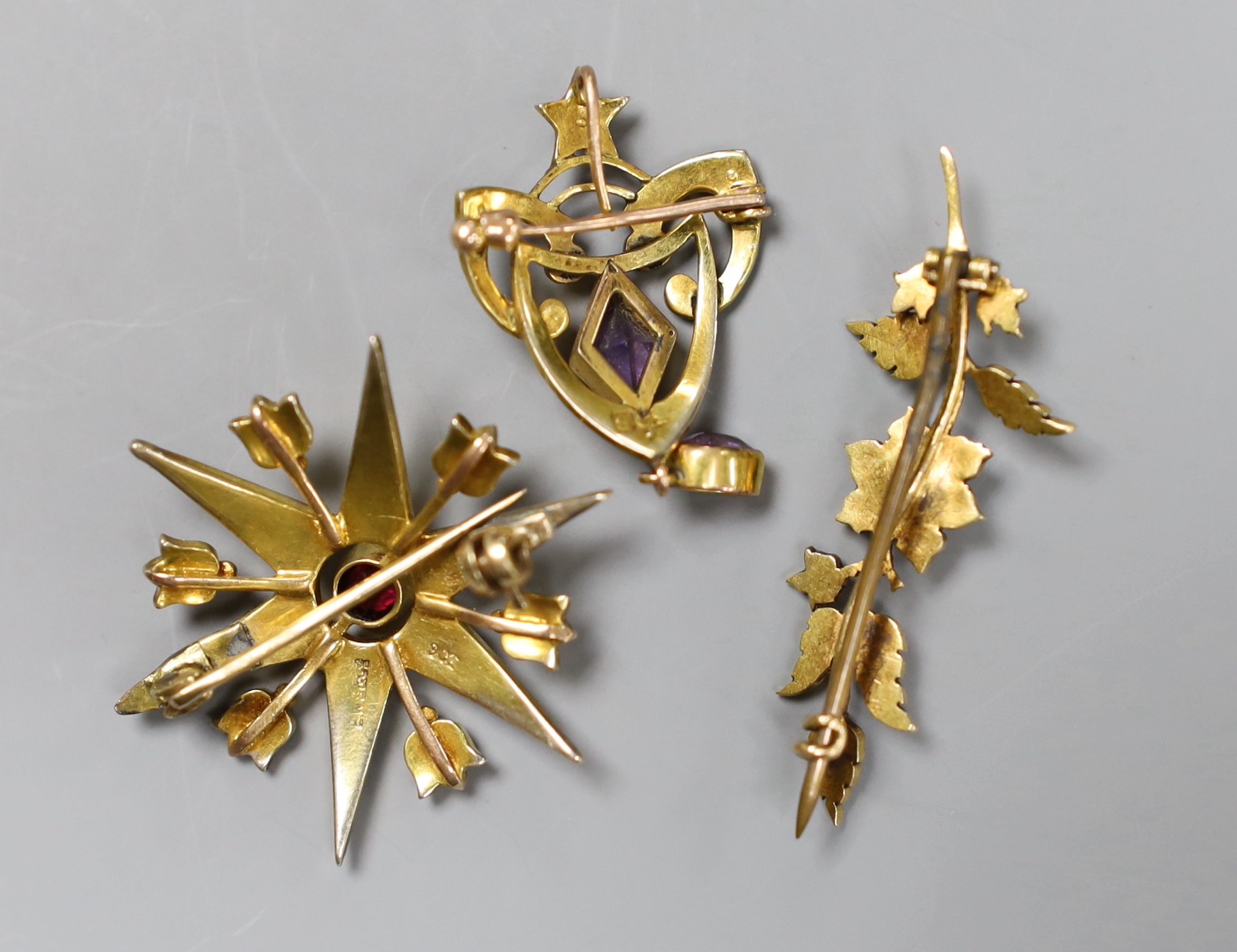 An Edwardian 9ct gold seed pearl and simulated ruby starburst brooch, 3.25cm, a pearl set bar brooch and an amethyst set drop brooch, gross 11.3 grams